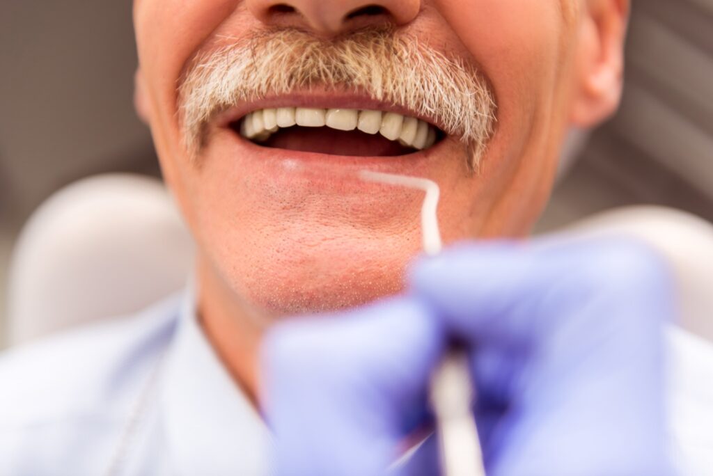 Elderly man on a review of a dentist, sitting in a chair